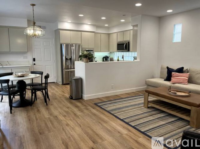 A modern kitchen with a dining table and chairs.