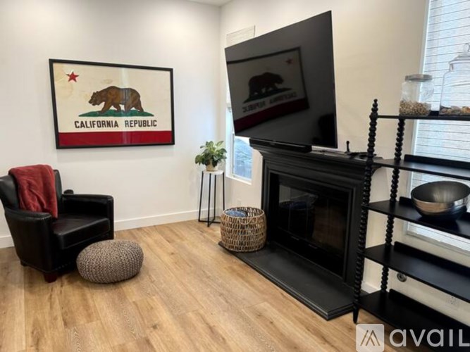 A living room with a fireplace and a California Republic picture on the wall.