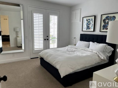 A bedroom with a large bed and a mirror on the wall.