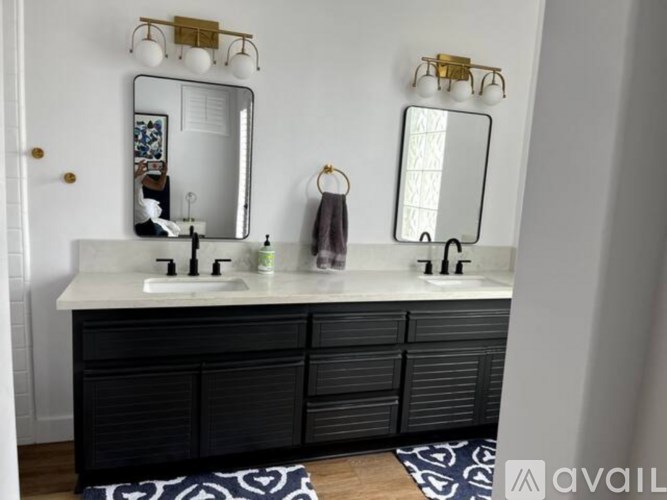 A bathroom with a vanity and two mirrors.