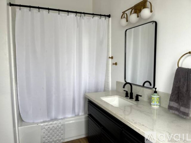A white shower curtain is hanging in a bathroom.