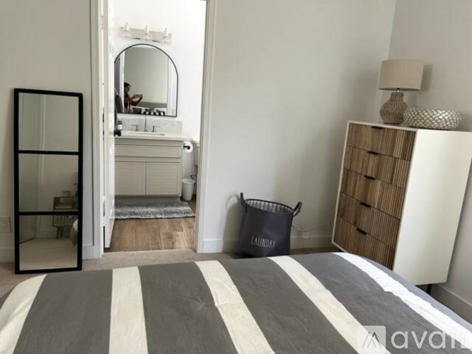 A bedroom with a striped bedspread and a wooden wardrobe.