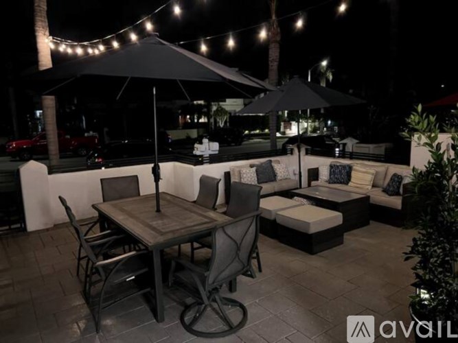 A patio with a table and chairs under umbrellas.
