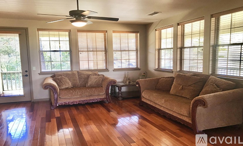 A living room with two couches and a fan.