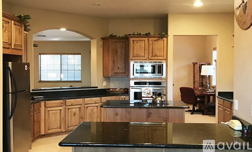 A kitchen with wooden cabinets and a black countertop.