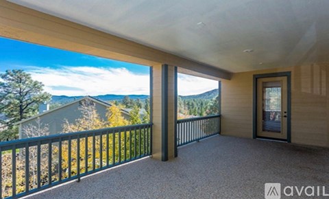 A balcony with a view of the mountains and trees.
