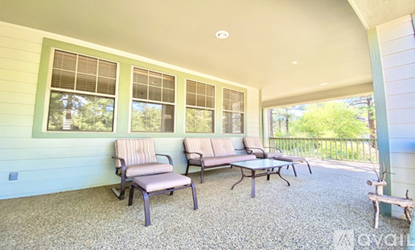 A patio with a couch, chairs, and a table.