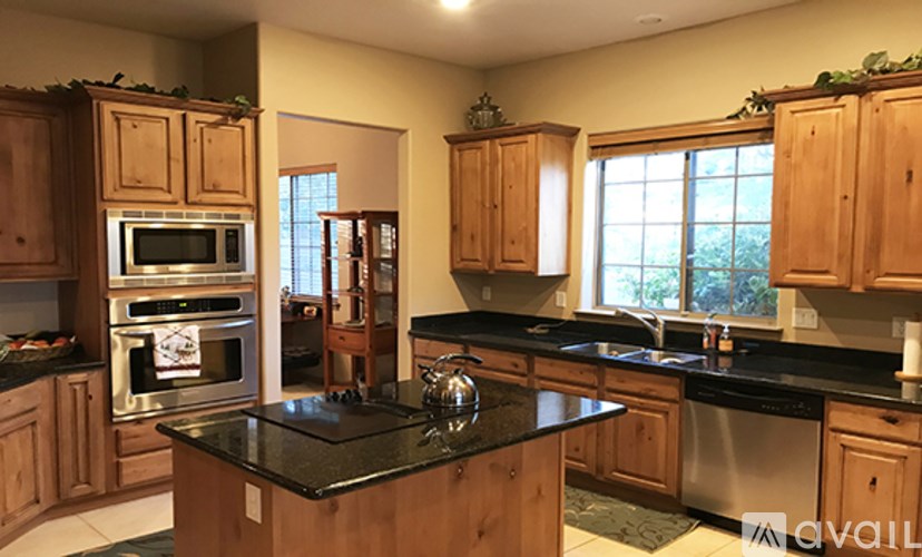 A kitchen with wooden cabinets and black countertops.