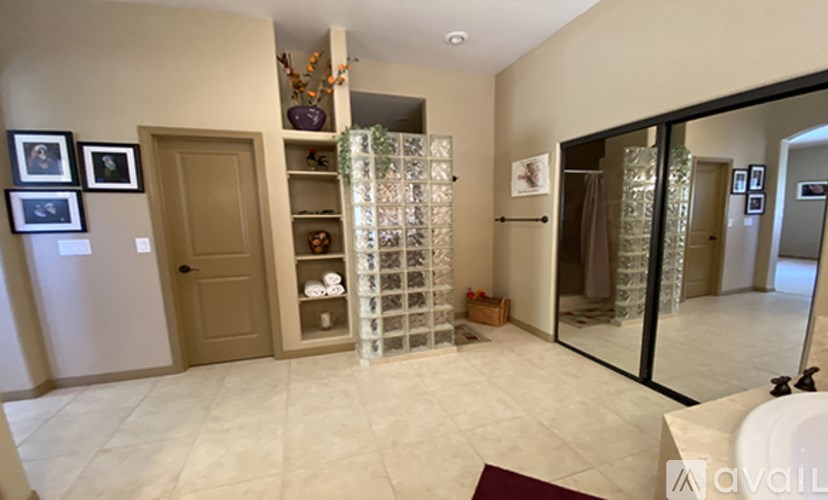 A hallway with a glass partition and a brown door.