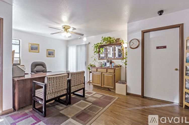 A living room with a couch, chair, and a plant on the windowsill.