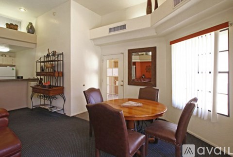 A dining room with a wooden table and chairs.