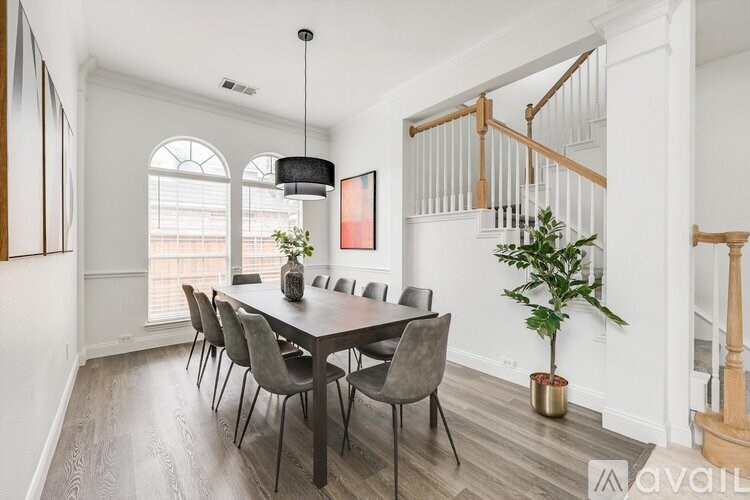 A dining room with a wooden table and chairs.