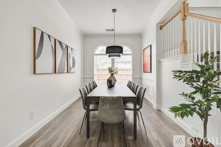 A dining room with a table and chairs.