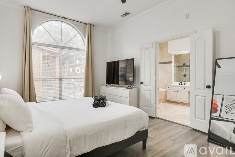 A bedroom with a large bed and a television in the corner.