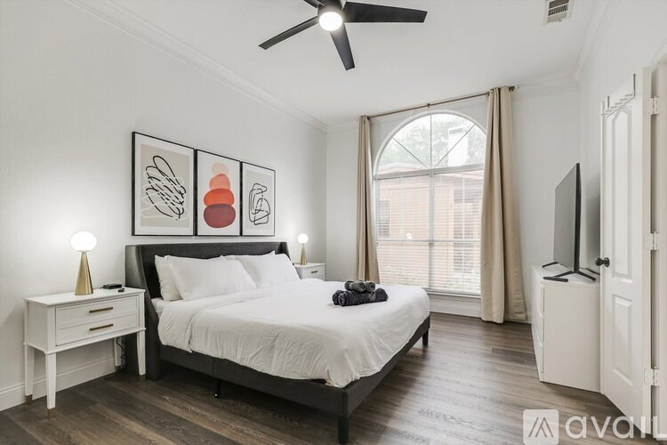 A bedroom with a bed, nightstand, and a ceiling fan.