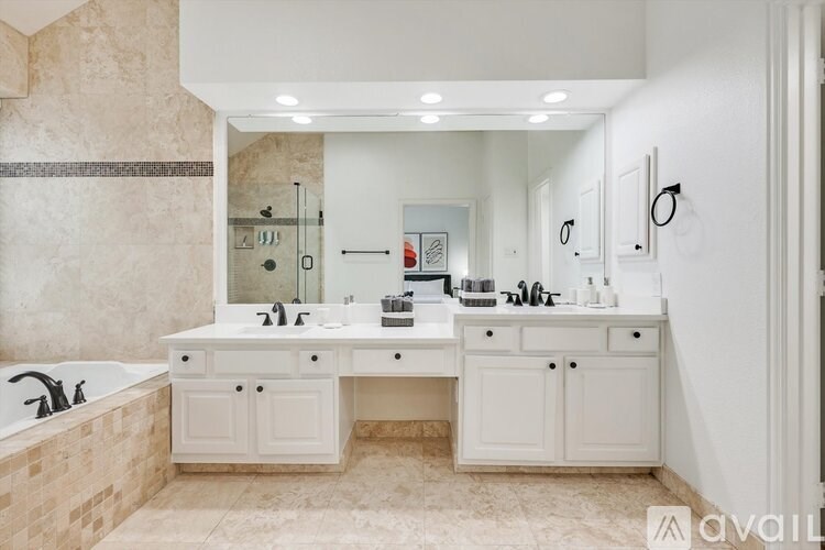 A bathroom with a tub, sink, and mirror.