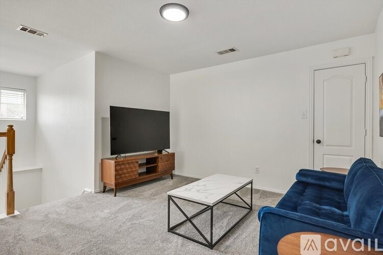 A living room with a blue chair and a flat screen TV.