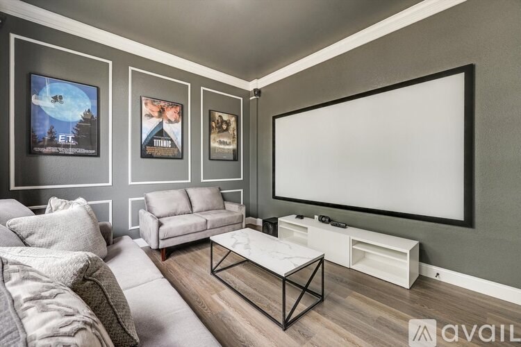 A modern living room with a large TV and a coffee table.