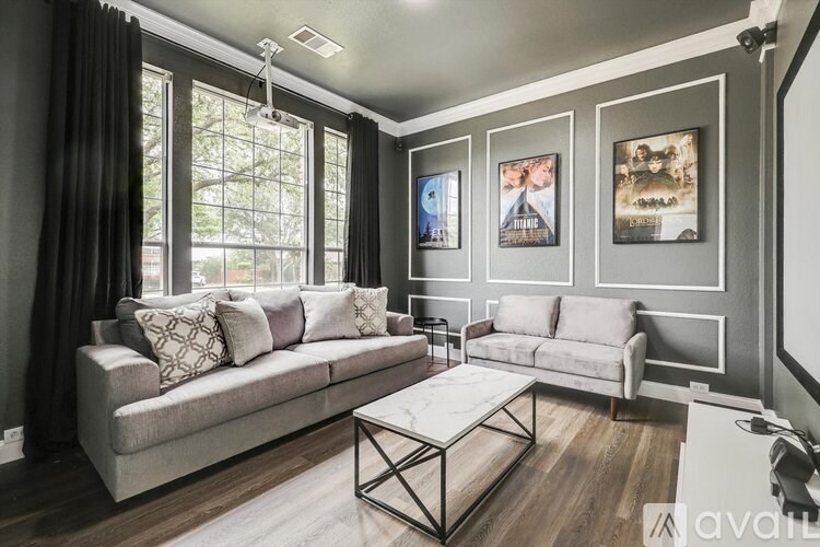 A living room with a large window, two couches, and a coffee table.