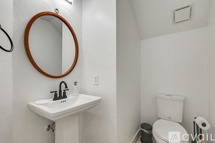 A bathroom with a white sink and toilet.