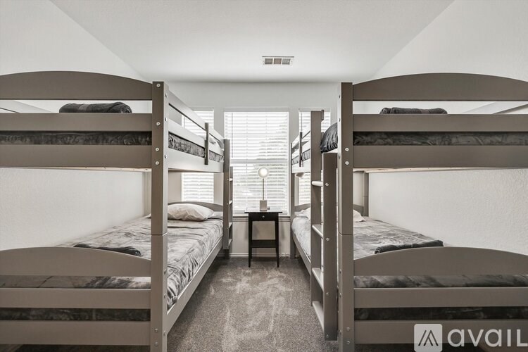 A room with bunk beds and a table in the middle.
