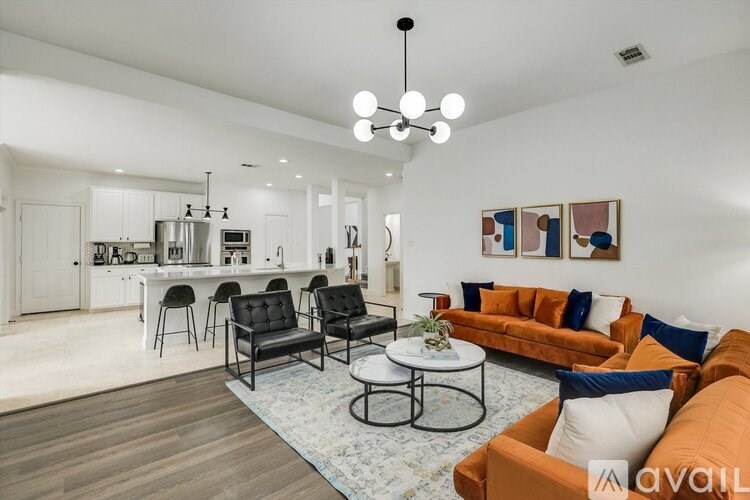 A modern living room with a kitchen area in the background.