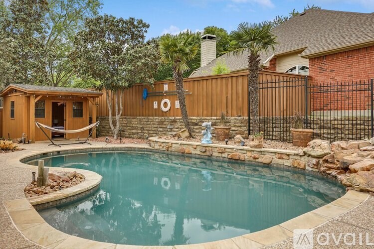 A backyard with a pool and a wooden fence.
