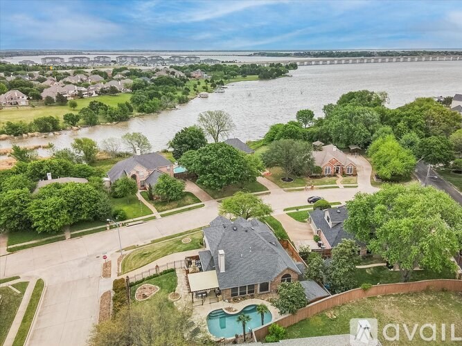A bird's eye view of a house with a pool and a backyard with a tree.