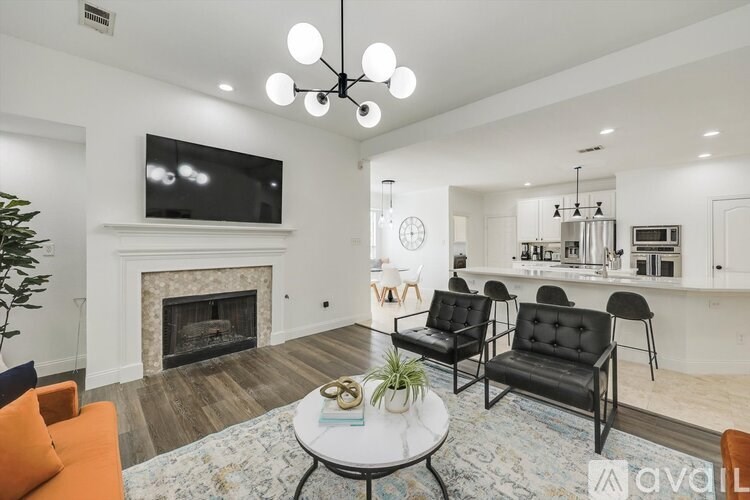 A living room with a fireplace, a television, and a dining area with chairs and a table.