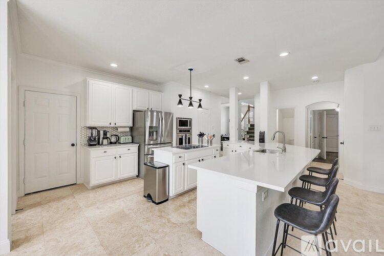 A modern kitchen with white cabinets and a large island.