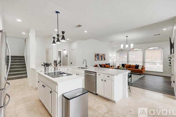 A modern kitchen with white cabinets and a large island.