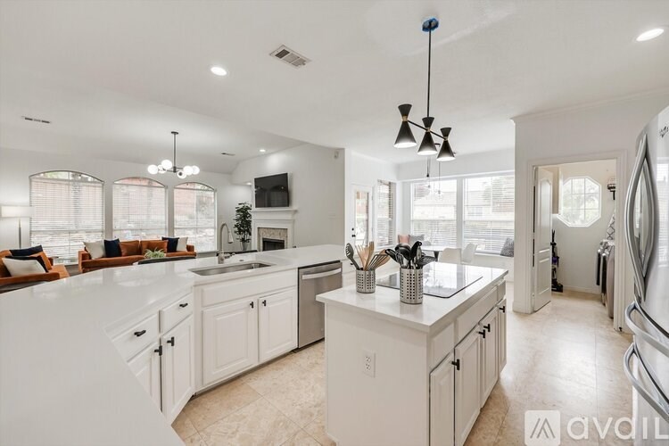 A modern kitchen with white cabinets and a central island.