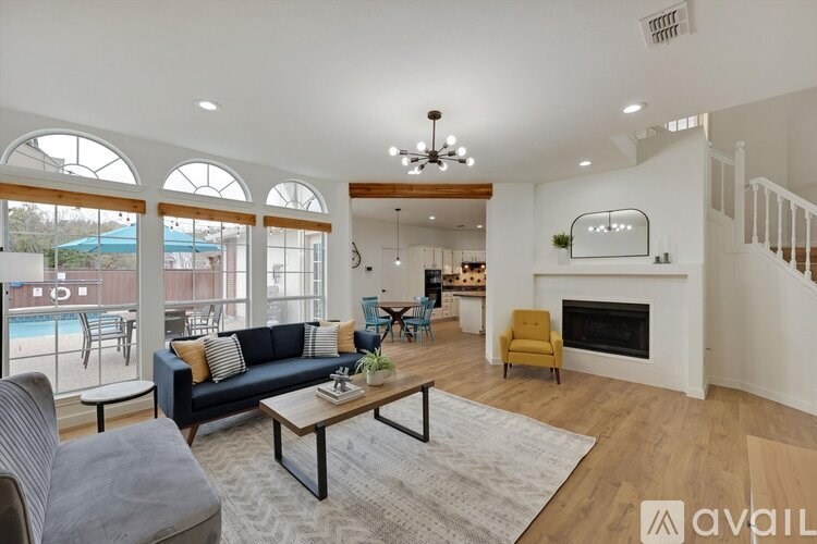 A living room with a black couch, a coffee table, and a fireplace.
