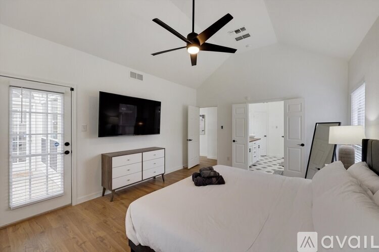 A bedroom with a bed, dresser, and television.