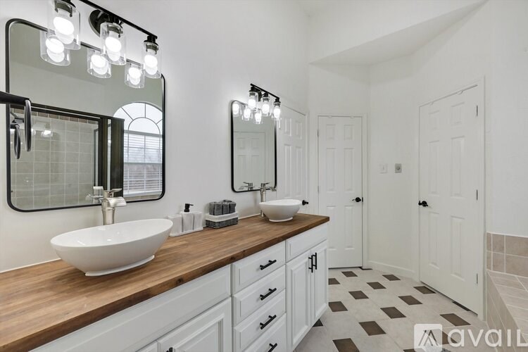 A bathroom with a white sink and a mirror above it.