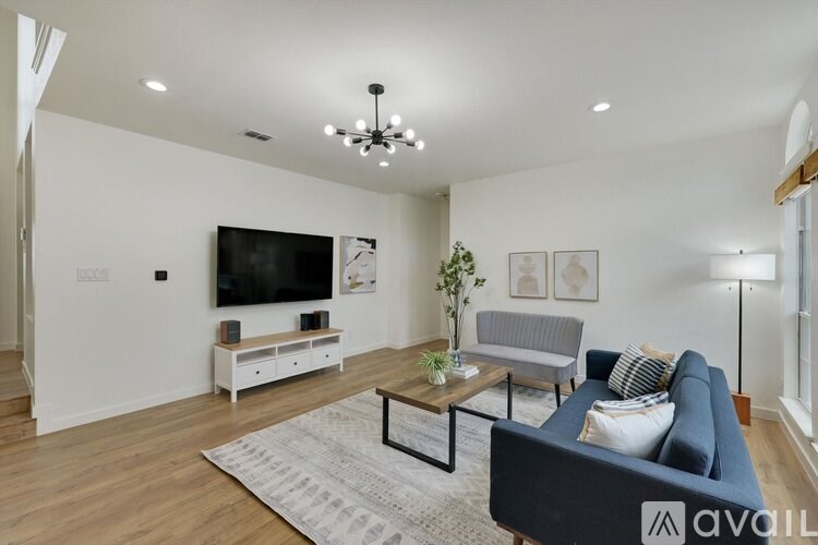 A living room with a dark blue couch and a white television.