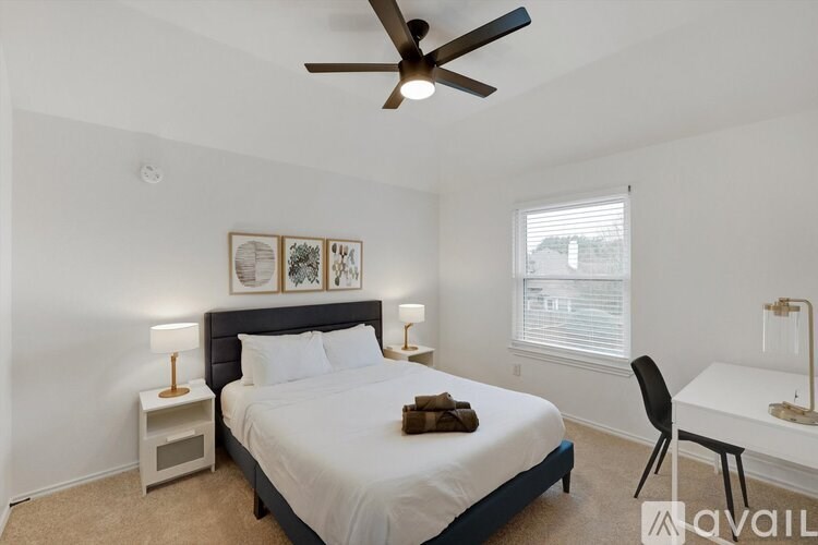 A bedroom with a bed, desk, and chair.