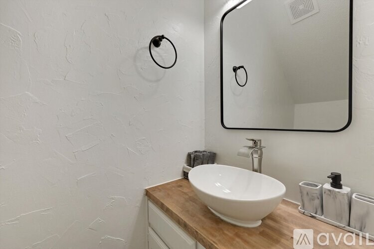 A bathroom with a white sink and a mirror.