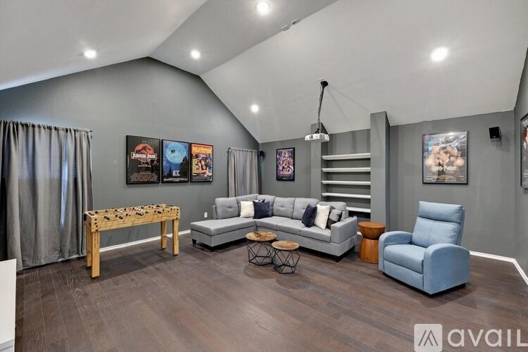 A living room with a grey couch, a wooden table, and a blue armchair.