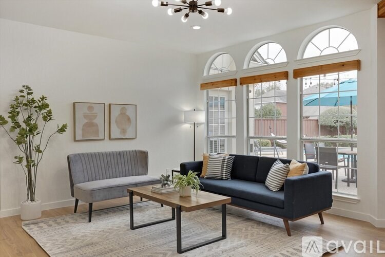 A living room with a grey couch, a coffee table, and a ceiling fan.