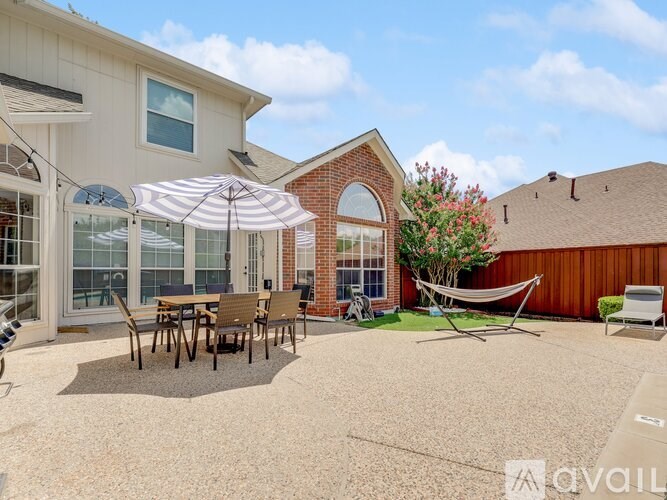 A patio with a table and chairs under an umbrella.