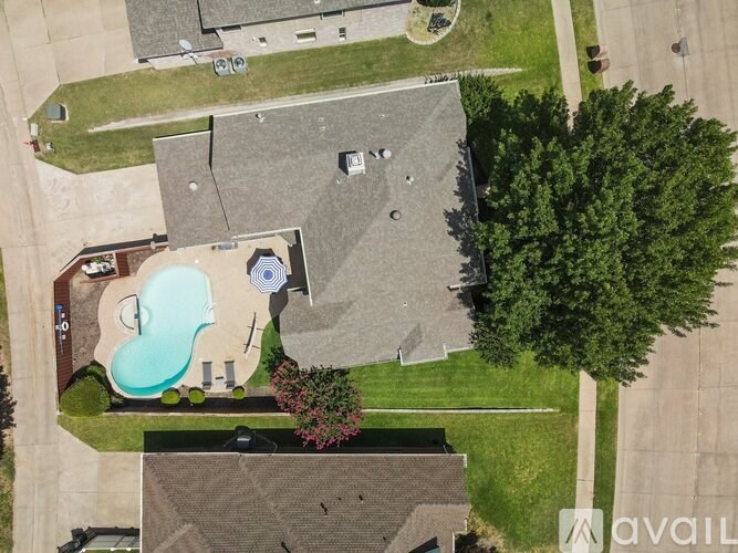A bird's eye view of a house with a pool and a tree.