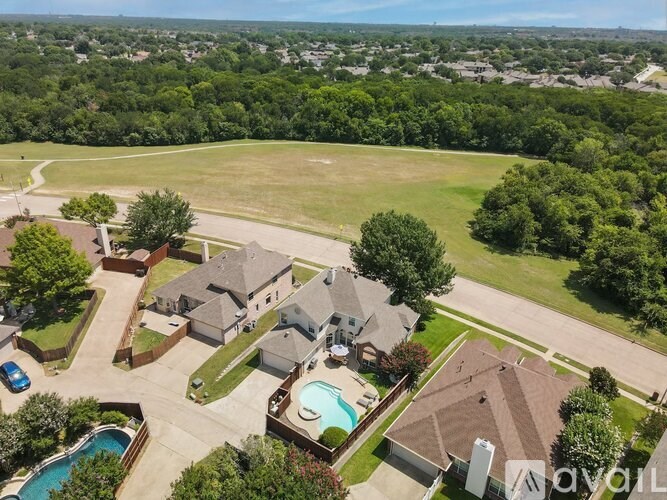A bird's eye view of a residential area with houses, a swimming pool, and a car.