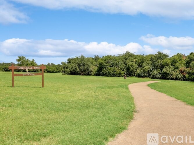 A sign in a field that says Hobbitville Park.