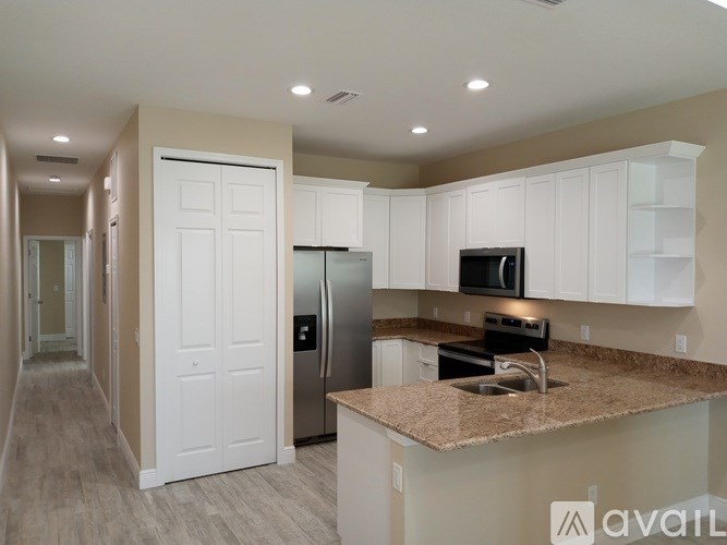 A kitchen with a granite countertop and white cabinets.
