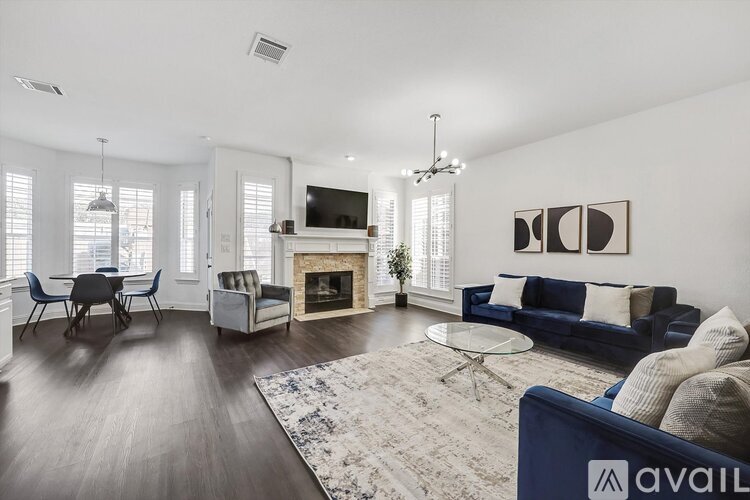 A living room with a blue couch and a fireplace.