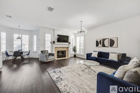 A living room with a blue couch and a fireplace.