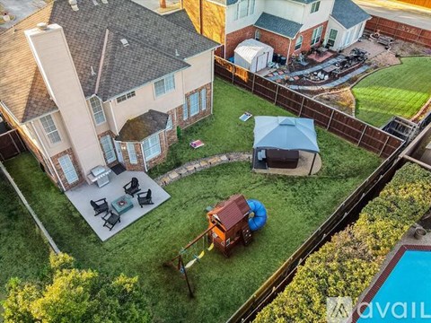 A backyard with a patio, a hot tub, and a pool.