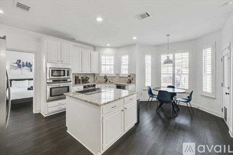 A modern kitchen with a dining table and chairs.