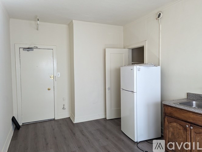 A small kitchen with a white fridge and a sink.